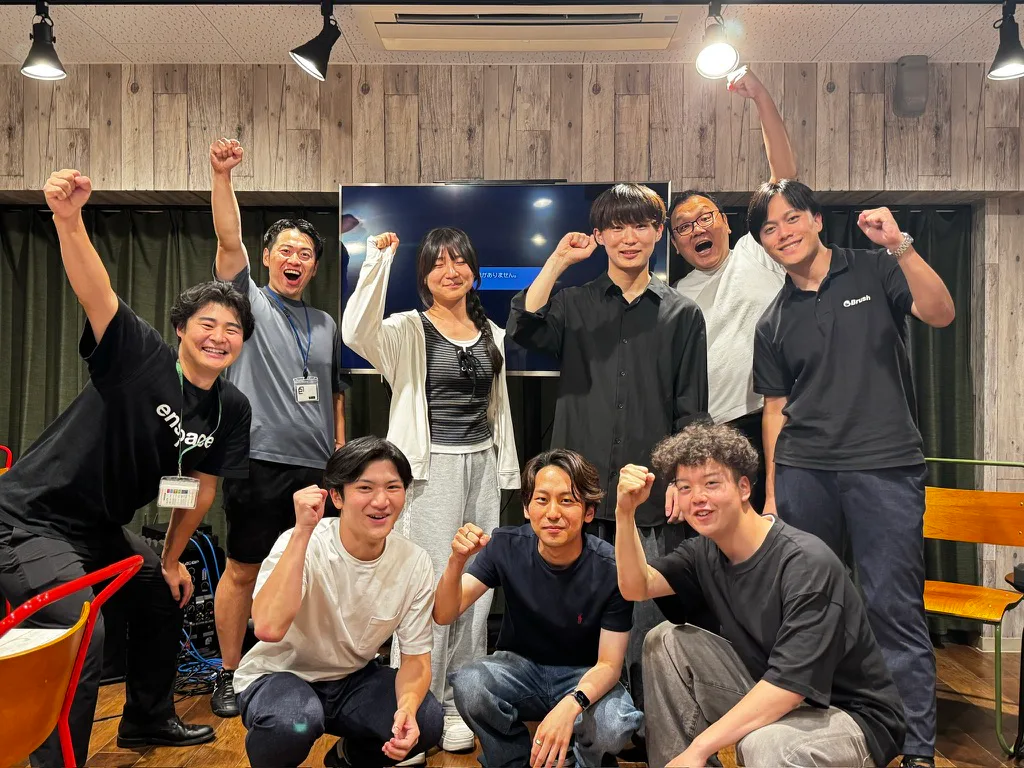会場で拳を上げる運営メンバー