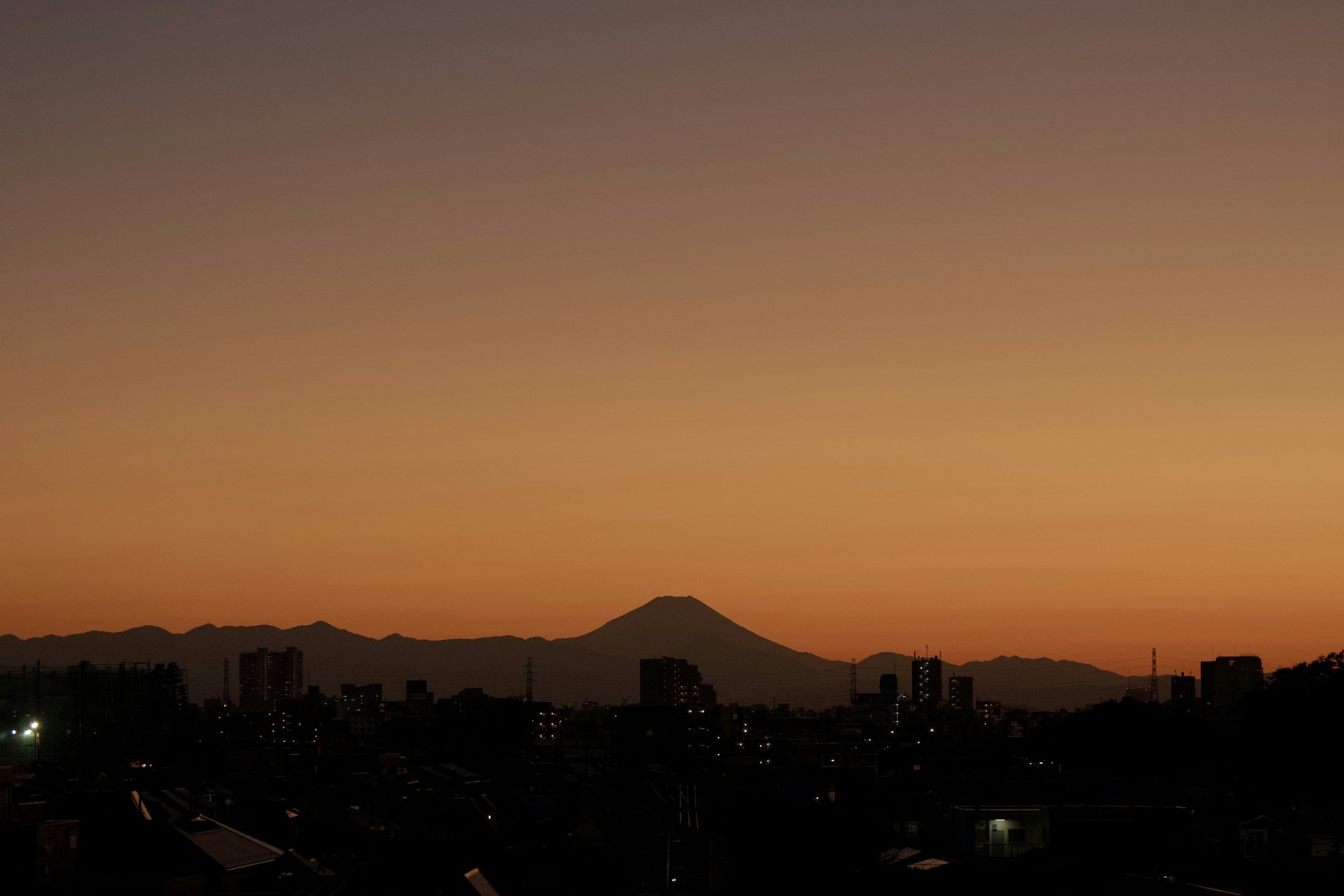 夕焼けに浮かぶ山と街のシルエット